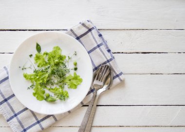 Beyaz tabakta mikro-yeşil salata, üst manzara, boş alan.