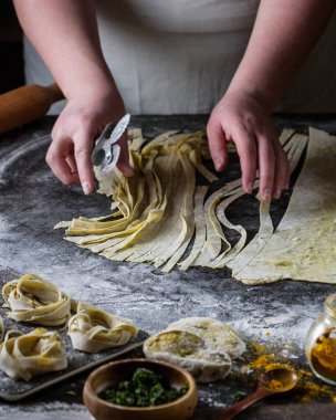 Bir kadın masadaki ev yapımı renkli macunu kesiyor..