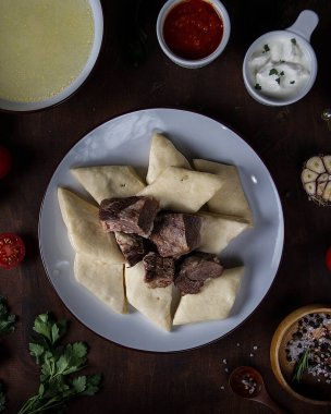 Karanlık bir masada Katmanlı Dagestani Khinkal.