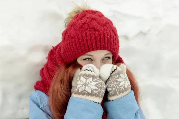 穿着红帽子和红衣服站在巨大雪堆前的年轻漂亮女子的画像 — 图库照片