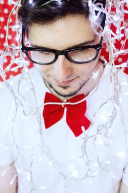 Genç hipster adam resmi giyim ve Noel ışıkları giyen bir yılbaşı partisinde 