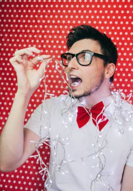 Genç hipster adam resmi giyim ve Noel ışıkları giyen bir yılbaşı partisinde 