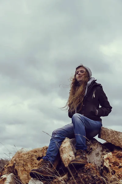 Beautiful woman on rocky hill — Stock Photo, Image