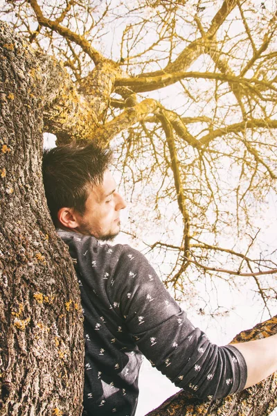 Uomo sul ramo di un albero — Foto Stock