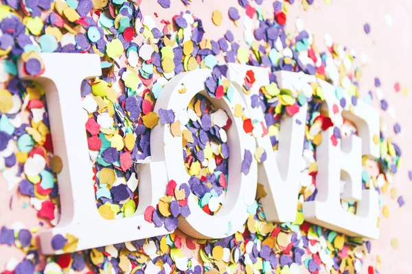 Słowo miłość z kolorowego papieru bitów — Zdjęcie stockowe