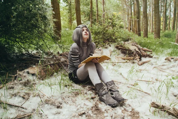 Жінка в лісі читає книгу — стокове фото