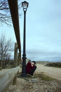 Genç kadın açık kırmızı kazak ve şapka poz