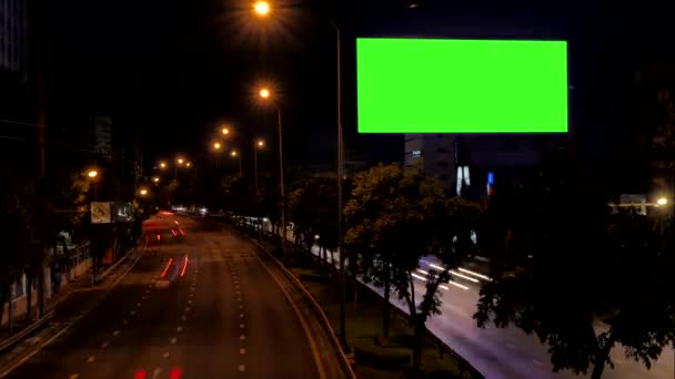 Zelená obrazovka prázdná reklama Billboard vedle silnice s provozem v noci, pro reklamu, časová prodleva.