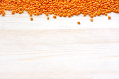 Ahşap masa arka plan kenar kuru turuncu kırmızı mercimek ile.