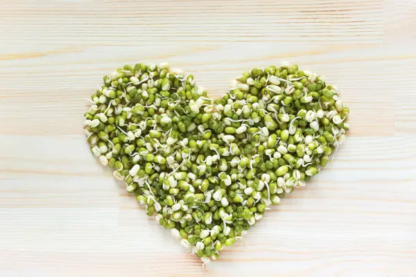 Forma de coração feito de feijão verde mung com brotos em woode luz — Fotografia de Stock