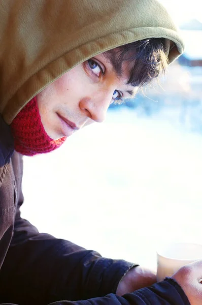 Młody przystojny mężczyzna picia gorących napojów w mroźną zimę rano — Zdjęcie stockowe
