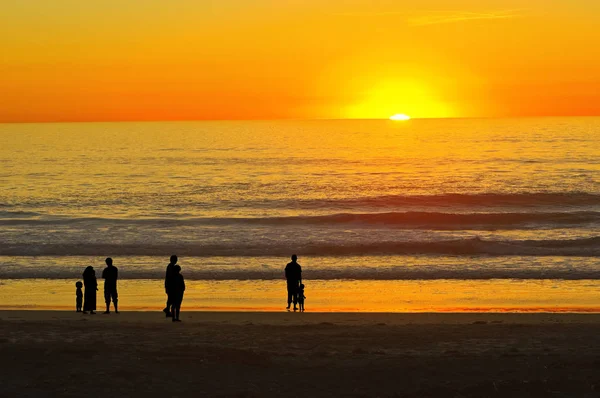 カリフォルニア サンセットビーチを人々 のシルエット — ストック写真