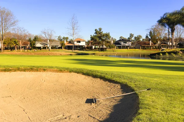 Zand van de bunker op de golfbaan met groen gras, bomen en vijver — Stockfoto