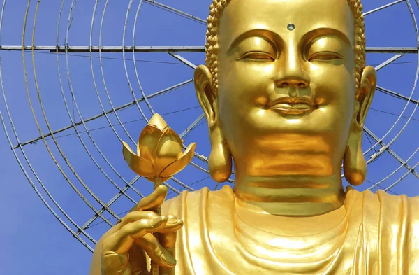 Złoty posąg Buddy z ręka trzyma kwiat na tle błękitnego nieba (Dalat, Wietnam) — Zdjęcie stockowe