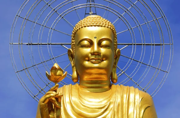 Goldene Buddha-Statue mit händchenhaltender Blume auf blauem Himmel (da lat, Vietnam) — Stockfoto