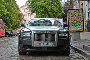 5 Ağustos 2012, Kiev, Rolls Royce Ghost. İngilizce araç İngiliz otobüsün arka plan. Yağmurda araba. Yağmur damlaları. Editoryal fotoğraf.