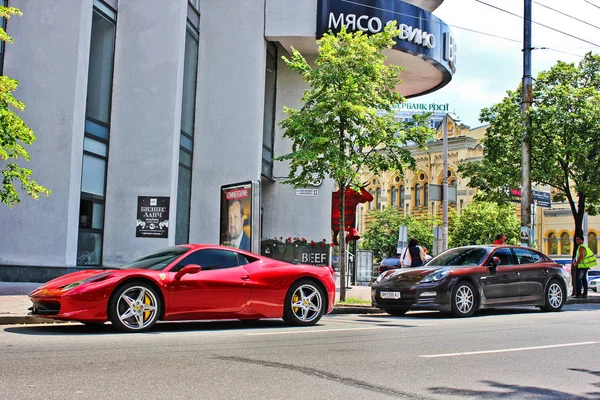 Kiew, Ukraine. 10. juni 2013 ferrari 458 italia & porsche panamera in der stadt. Roter Ferrari. Redaktionsfoto. — Stockfoto