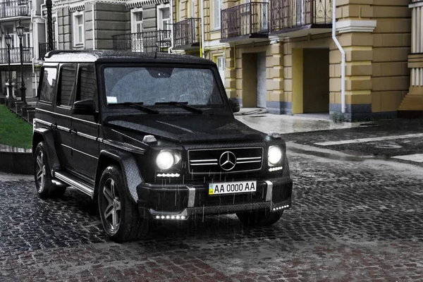 19 Haziran 2013. Ukrayna, Kiev. Mercedes-Benz G55 Amg arka planda eski ev sahipliği yapmaktadır. Yağmurda araba. Yağmur damlaları. Editoryal fotoğraf.