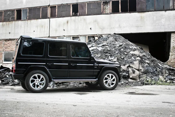 Ucrania, Kiev; 5 de septiembre de 2012; Mercedes-Benz G55 AMG. Brutal coche todoterreno sobre un fondo de ruinas de edificios. Un todoterreno. Foto editorial . — Foto de Stock