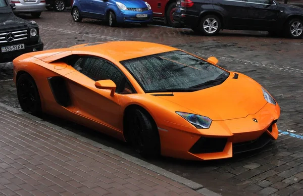 Kiev, Ucraina; 4 luglio 2013; Primo piano Lamborghini Aventador per le strade. Arancione. La macchina sotto la pioggia. Gocce di pioggia. Foto editoriale . — Foto Stock