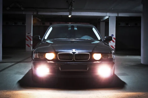 December 23, 2014, Odessa, Ukraina. underjordisk parkering. BMW 7 (e38) i skuggorna med glödande lampor i svagt ljus. Bil. Redaktionella foto. — Stockfoto