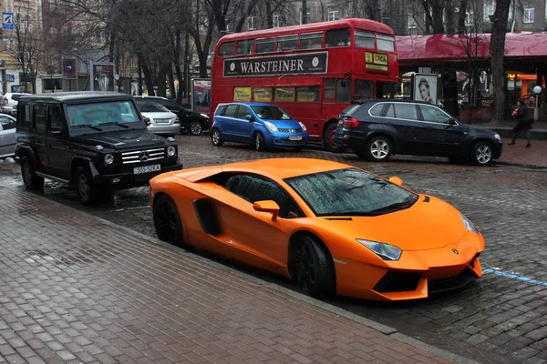 Kyjev, Ukrajina; 4. července 2013; Lamborghini Aventador a Mercedes-Benz G55 Amg na ulicích. Oranžová. Auto v dešti. Dešťové kapky. Redakční Foto. — Stock fotografie