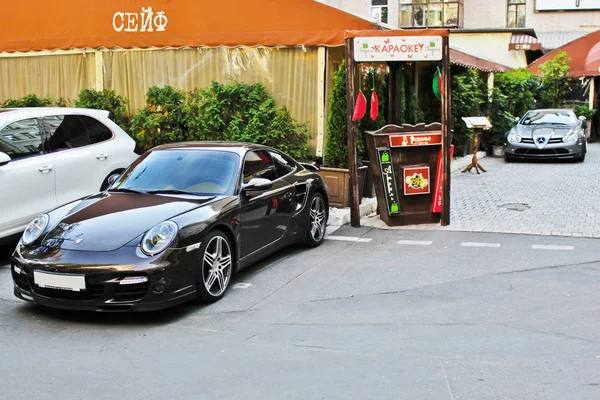 25 de setembro de 2016; Ucrânia, Kiev; Mercedes-Benz SLR McLaren 722 Edition e Porsche 911 Turbo S no fundo do restaurante. Café velho. Foto editorial . — Fotografia de Stock