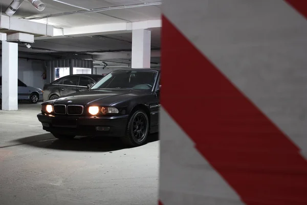 December 23, 2014, Odessa, Ukraine. underground parking. BMW 7 (e38) in the shadows with glowing lights in low light. Car. Editorial photo. — Stock Photo, Image