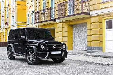 Kiev, Ukrayna; 21 Nisan 2015. Mercedes-Benz G55 Amg arka planda eski evler sarı. Editoryal fotoğraf.