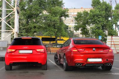 Kiev, Ukraine; June 25, 2013; BMW M6 and Audi A3 on the road in heavy rain. Back view. Editorial photo. clipart