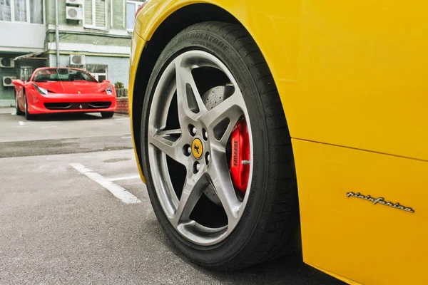 27 februarie: Ucraina, Kiev; Ferrari 458 Italia și Ferrari 458 Spider, Galben și roșu. Roțile mașinii se închid pe un fundal de asfalt. Anvelope auto. Roata de aproape. Fotografie editorială . — Fotografie, imagine de stoc