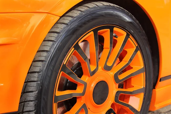 Car wheels close up. Tuning. Orange luxury car. Supercar. Orange. England. Tuning. Karbon. Europe. Car tires. Car wheel close-up. for advertising (for advertising).