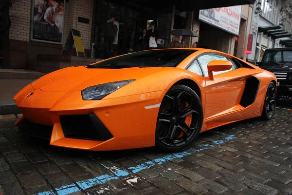 Kiev, Ucraina; 1 luglio 2012; Lamborghini Aventador per le strade. La macchina. Arancione. In città. Lussuoso. Mi sintonizzo. Supercar. La macchina sotto la pioggia. Gocce di pioggia. Foto editoriale . — Foto Stock