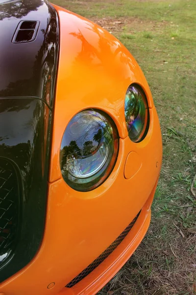 Partie voiture orange sur fond d'asphalte. Tuning. Orange voiture de luxe — Photo