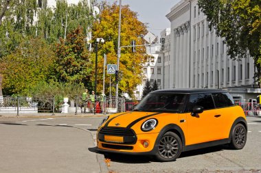 Kiev, Ua - 24 Ağustos 2017: Turuncu Mini Cooper state Binası ve askeri arka plan üzerinde