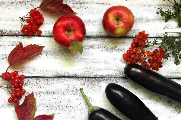 Composition automnale sur fond bois. Pommes, viornes, aubergines, feuilles et fleurs — Photo