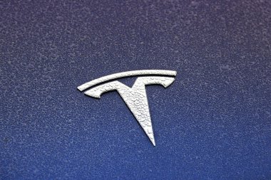 Chernihiv, Ukrayna, 29 Ekim 2019: Elektronik bir araba Tesla amblemi. Yağmur damlalarında araba