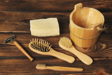 Banyo ahşap bir arka planda. Havlu, jilet, fırça ve tarak.