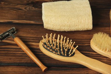 Banyo ahşap bir arka planda. Havlu, jilet, fırça ve tarak.