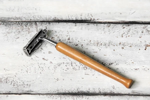 Wooden razor on a white wooden background — Stockfoto