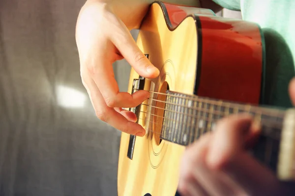 The guy with the guitar. Guitar in the hands of a guy.