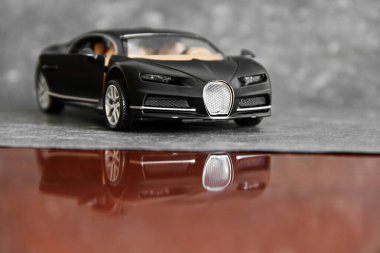 Gri arka planda siyah bir araba.