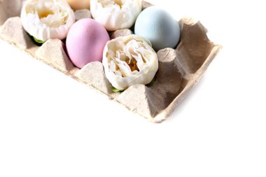 Beyaz arkaplanda bir tepside yumurta ve çiçekler