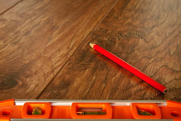 Optical level and a pencil lying on the floor