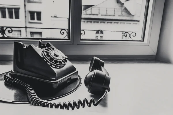 Teléfono viejo está en ventana de vinilo — Foto de Stock