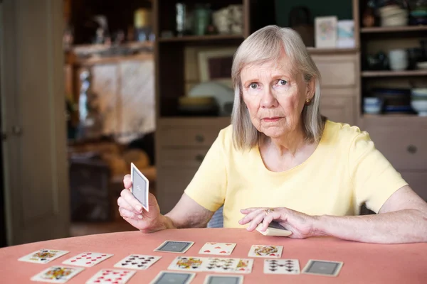 Donna che tiene la carta da gioco a tavola — Foto Stock