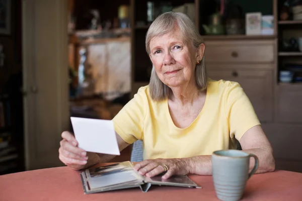 Grinning woman holding photograph — Stock Photo, Image