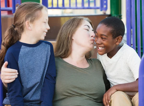 Mother kissing adopted son on cheek — Stock Photo, Image