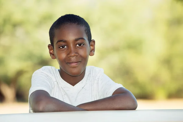 Cute child with folded arms at table Stock Photo