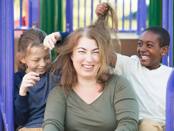 Filhos brincando com o cabelo da mãe — Fotografia de Stock